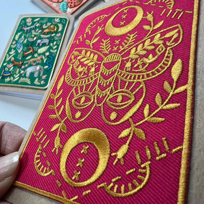 3.5 inch pocket notebook with embroidered patch attached to the front of gold stitched moth on a red background by Rikrack