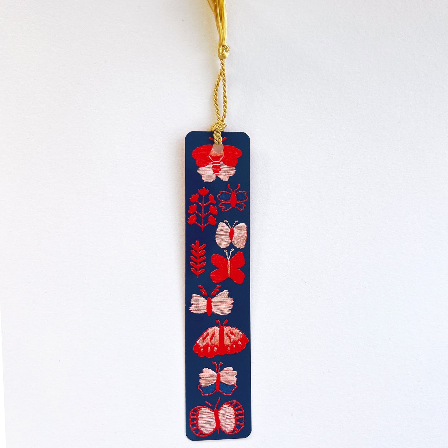 1.5 x 7 inch Dark blue bookmark with pink and red embroidered butterflies and gold tassel by Rikrack